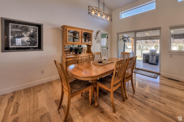 4230 S Beeman Rd, Moab, UT 84532 - dining room with a high ceiling, a healthy amount of sunlight, a notable chandelier, and light hardwood / wood-style flooring