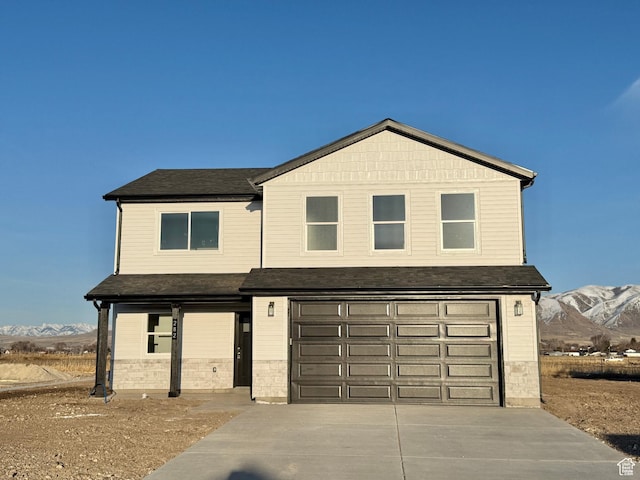 view of front of house with a mountain view, an attached garage, and driveway