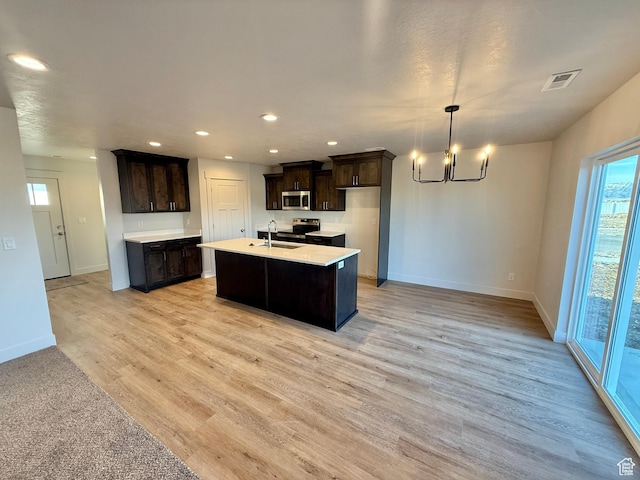 kitchen featuring visible vents, dark brown cabinetry, light countertops, appliances with stainless steel finishes, and a sink