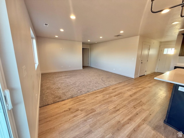 unfurnished living room with recessed lighting, visible vents, and light wood finished floors