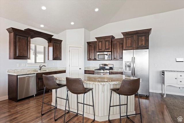 1321 Highland Blvd N, Brigham City, UT 84302 - kitchen with stainless steel appliances, dark brown cabinetry, a kitchen island, a kitchen breakfast bar, and lofted ceiling