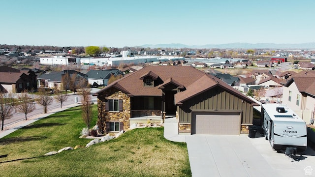1321 Highland Blvd N, Brigham City, UT 84302 - view of front facade with board and batten siding, stone siding, driveway, a front yard, and a residential view