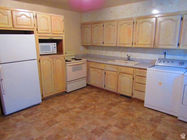 kitchen with sink, white appliances, washer and clothes dryer, and light brown cabinets