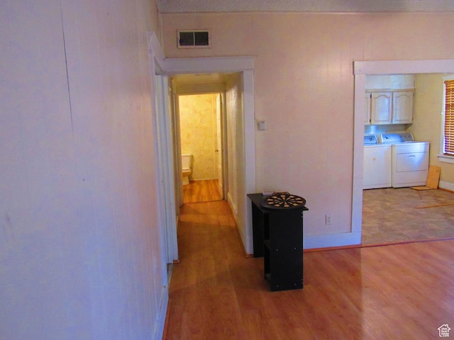 hall featuring separate washer and dryer and light hardwood / wood-style floors