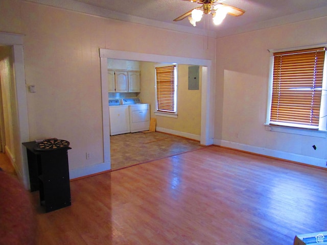 unfurnished room with washer and dryer, ornamental molding, electric panel, ceiling fan, and light hardwood / wood-style floors