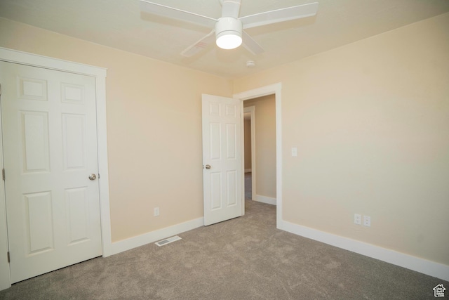 unfurnished bedroom featuring light colored carpet and ceiling fan