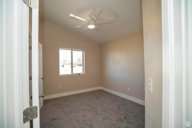 empty room with ceiling fan, lofted ceiling, and dark carpet