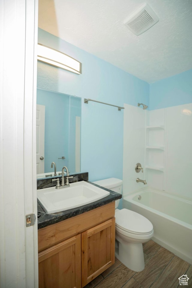 full bathroom featuring hardwood / wood-style flooring, vanity, toilet, and bathing tub / shower combination