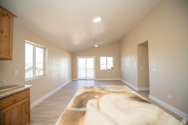 interior space with vaulted ceiling, ceiling fan, and light hardwood / wood-style flooring