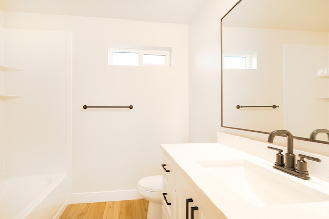 full bathroom featuring baseboards, toilet, wood finished floors, and a wealth of natural light