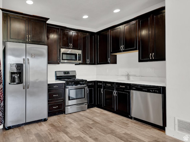 1726 W Thira Ln S, South Jordan, UT 84095 - kitchen with stainless steel appliances, a sink, light countertops, light wood finished floors, and recessed lighting