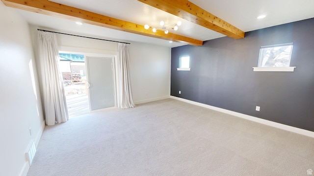 spare room with light colored carpet and beam ceiling