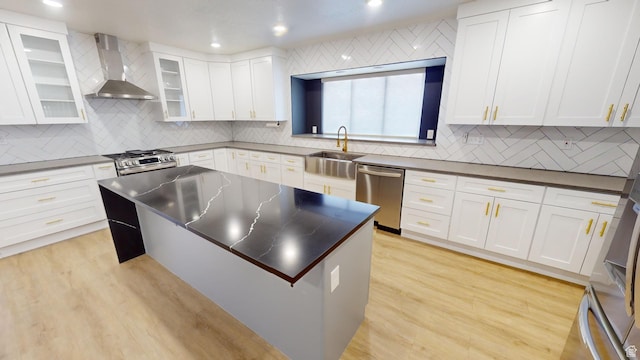 kitchen with white cabinets, stainless steel appliances, and wall chimney exhaust hood