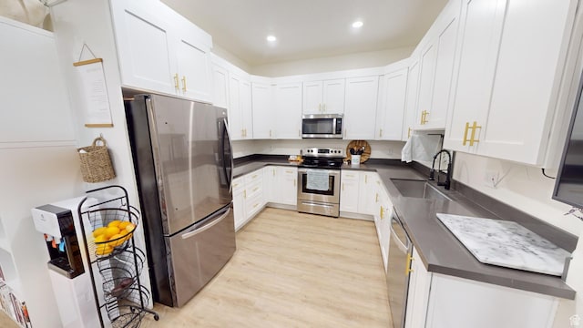 kitchen with sink, stainless steel appliances, light hardwood / wood-style floors, and white cabinets