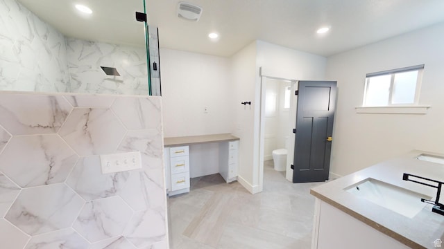 bathroom with vanity, a tile shower, and toilet