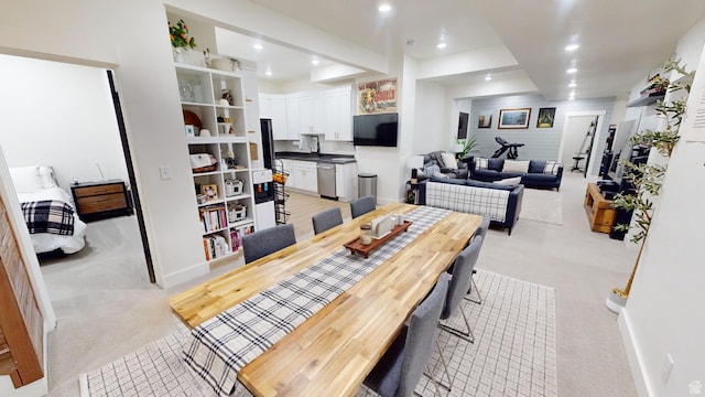 dining space featuring light carpet