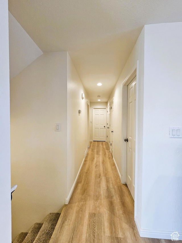 hallway featuring baseboards and light wood finished floors