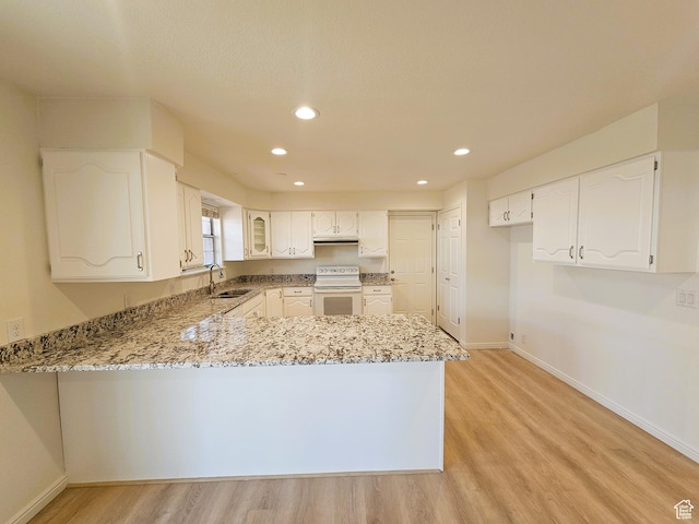 kitchen featuring electric range, a sink, light stone counters, light wood-style flooring, and a peninsula