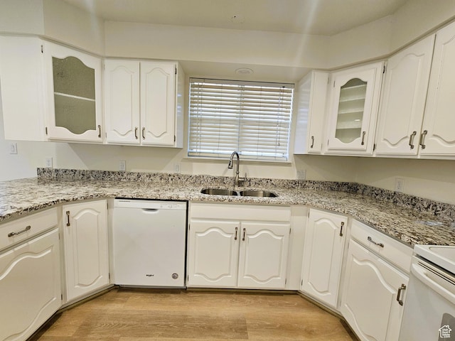 kitchen featuring white cabinets, dishwasher, glass insert cabinets, a sink, and light wood-style floors
