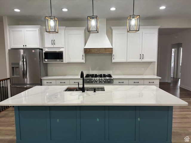 kitchen featuring white cabinets, dark wood-style floors, appliances with stainless steel finishes, custom exhaust hood, and a sink