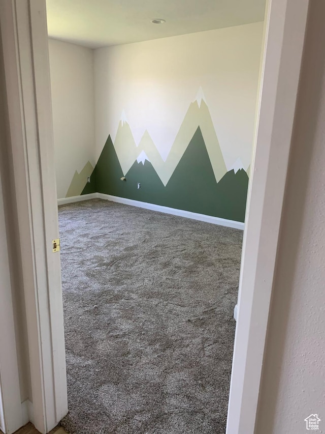 carpeted empty room featuring baseboards