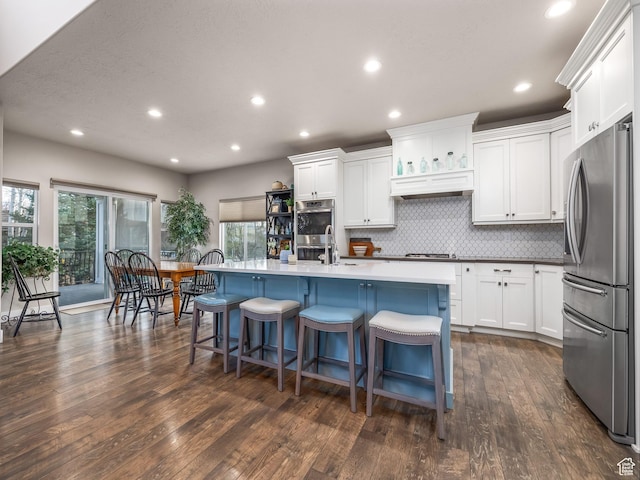 2654 E Water Wheel Ct, Heber City, UT 84032 - kitchen with a breakfast bar, white cabinetry, dark hardwood / wood-style flooring, a kitchen island with sink, and stainless steel appliances