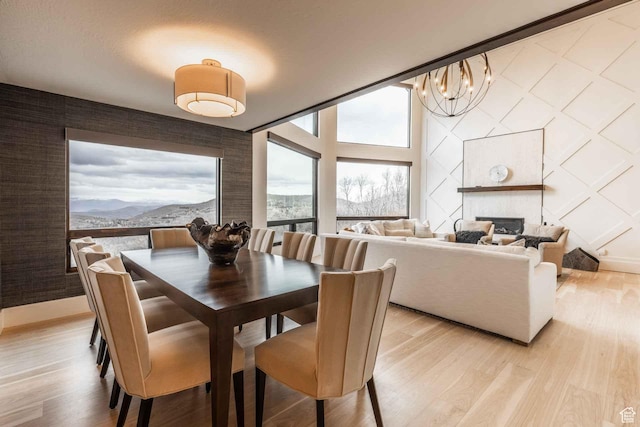 1555 Aerie Cir, Park City, UT 84060 - dining area with a chandelier, a large fireplace, a mountain view, and light hardwood / wood-style flooring