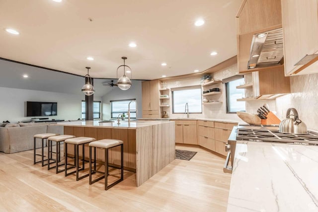 1555 Aerie Cir, Park City, UT 84060 - kitchen featuring light brown cabinetry, an island with sink, sink, a breakfast bar area, and light hardwood / wood-style flooring