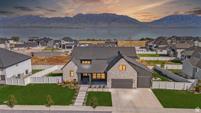 modern farmhouse style home featuring a water and mountain view and a lawn