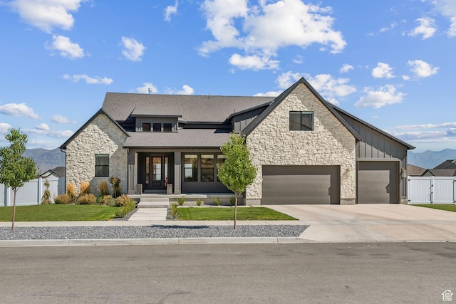 view of front of property featuring a mountain view, a garage, and a front lawn