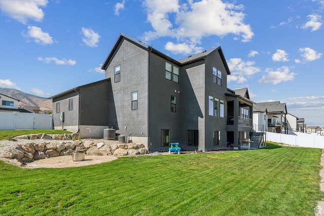 back of house featuring cooling unit, a yard, and a patio area