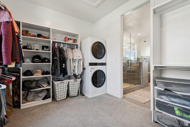 clothes washing area featuring stacked washing maching and dryer, light colored carpet, and a notable chandelier