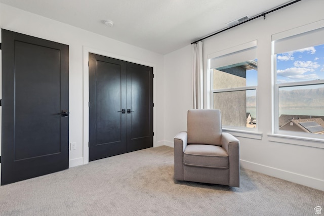 sitting room featuring light carpet and a wealth of natural light