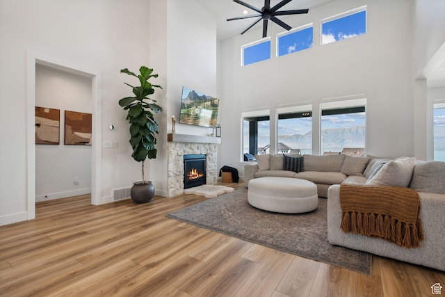 living room featuring a stone fireplace and hardwood / wood-style floors