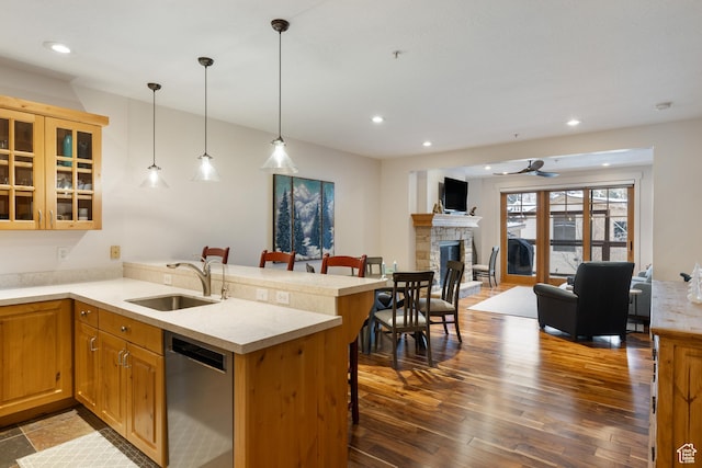 kitchen featuring pendant lighting, sink, a breakfast bar, stainless steel dishwasher, and kitchen peninsula