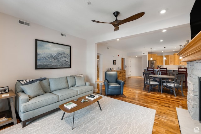 living room featuring ceiling fan and light hardwood / wood-style floors