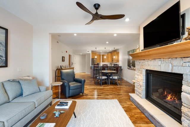 living room with ceiling fan, hardwood / wood-style floors, and a fireplace