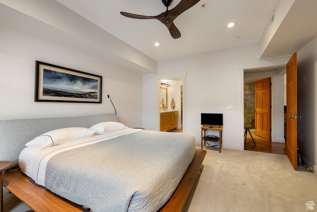 bedroom featuring ceiling fan, ensuite bath, and light carpet