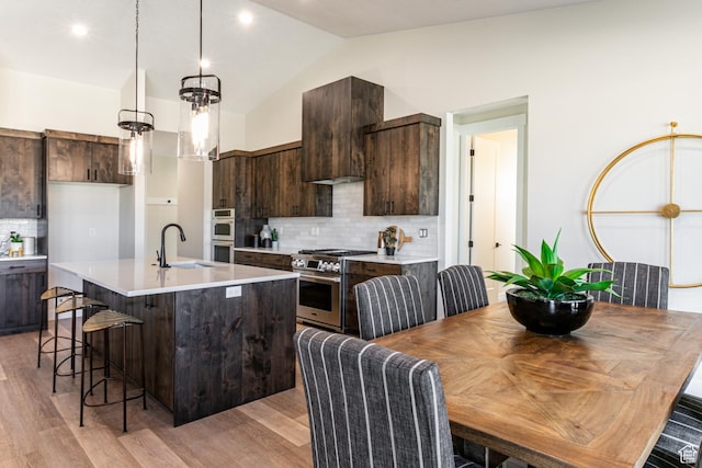 11202 S 1000 E Unit 3, Sandy, UT 84094 - kitchen with stainless steel appliances, an island with sink, dark brown cabinets, and pendant lighting