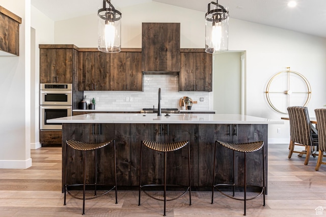 11202 S 1000 E Unit 3, Sandy, UT 84094 - kitchen featuring vaulted ceiling, stainless steel double oven, an island with sink, and hanging light fixtures