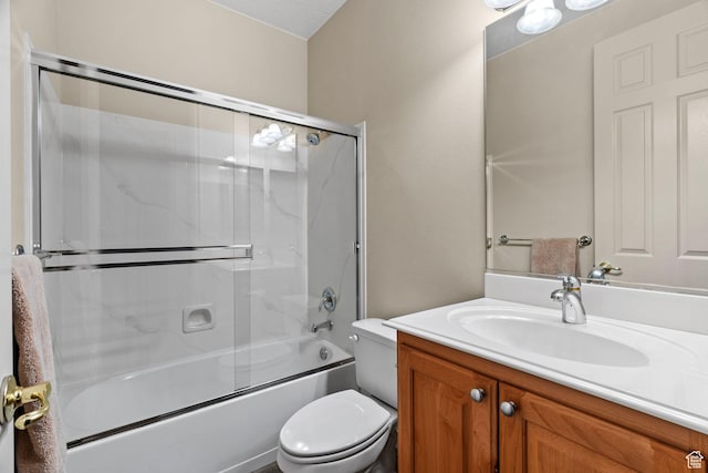 full bathroom with vanity, bath / shower combo with glass door, and toilet