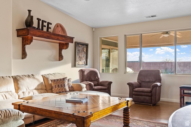 living room featuring a textured ceiling and ceiling fan