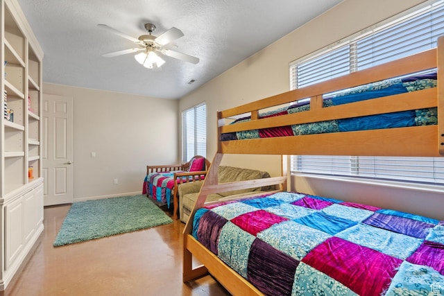 bedroom with ceiling fan and a textured ceiling