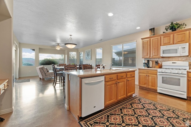 kitchen featuring tasteful backsplash, decorative light fixtures, a textured ceiling, white appliances, and a kitchen island with sink