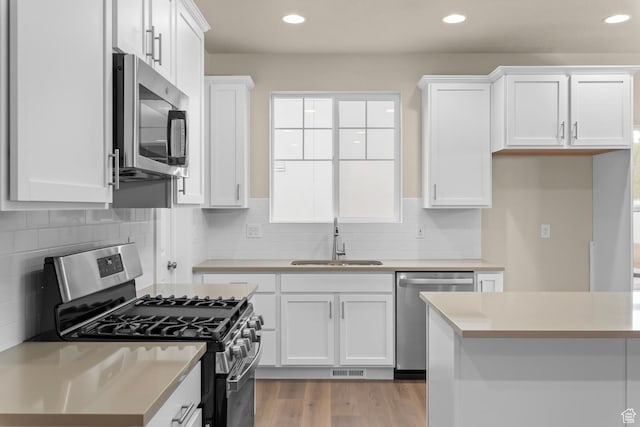11878 S Golden Pine Ln, Riverton, UT 84065 - kitchen with sink, light hardwood / wood-style flooring, appliances with stainless steel finishes, white cabinets, and backsplash