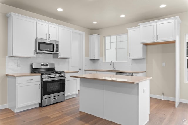11878 S Golden Pine Ln, Riverton, UT 84065 - kitchen with stainless steel appliances, white cabinetry, and a kitchen island