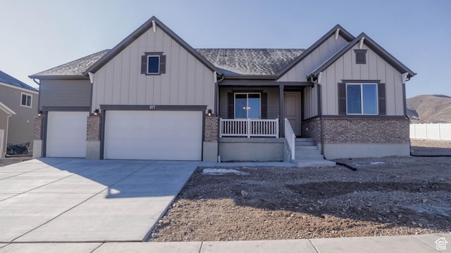 view of front facade featuring board and batten siding, concrete driveway, a garage, and covered porch