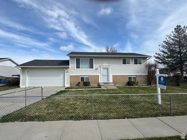 raised ranch featuring concrete driveway, brick siding, a front lawn, a fenced front yard, and a garage