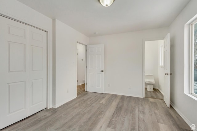 241 E Utah Ave, Tooele, UT 84074 - unfurnished bedroom with a closet, baseboards, ensuite bath, and light wood-style flooring