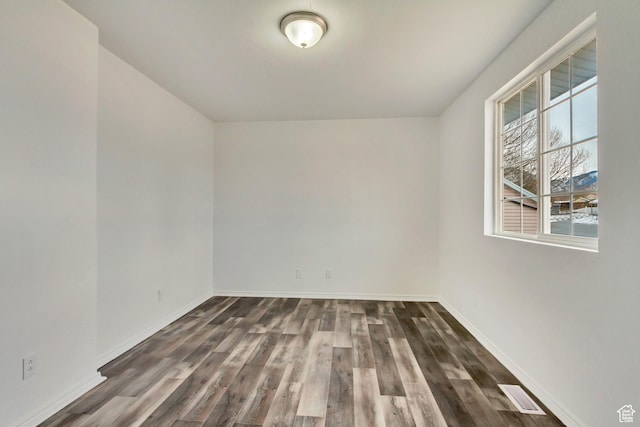 241 E Utah Ave, Tooele, UT 84074 - spare room with visible vents, dark wood-type flooring, and baseboards